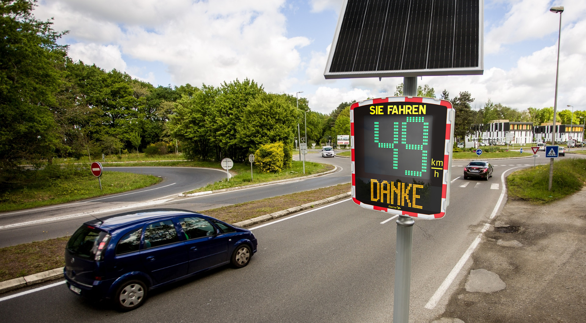 Ein vorbeifahrendes Auto, das vor einem Geschwindigkeitsmessgerät seine Geschwindigkeit von 37 km/h angezeigt bekommt.